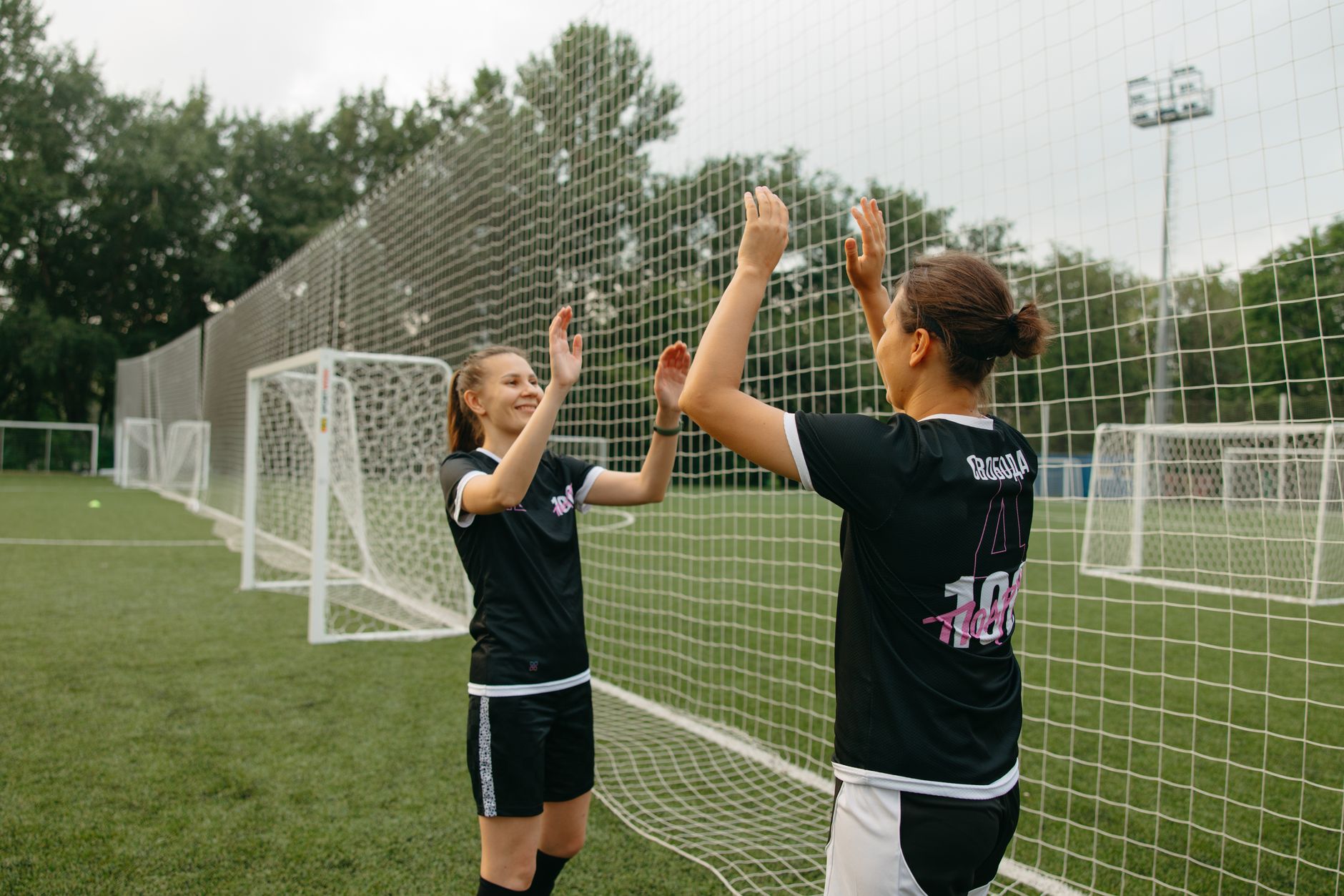 Two soccer players high-fiving during a team training session.